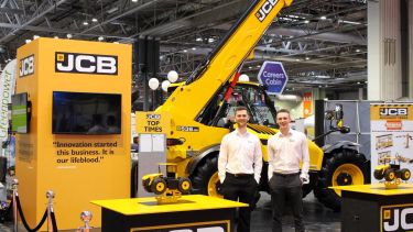 Year in Industry student James Holden at JCB in from of some JCB equipment.