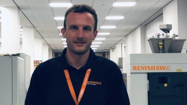 Year in Industry student James Wardle on placement. He has on a polo shirt and orange lanyard.