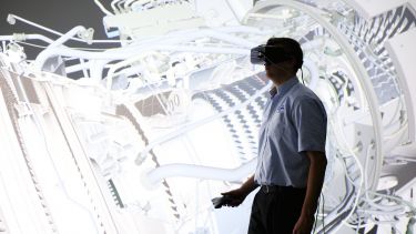 A man using a VR headset to examine a virtual turbine