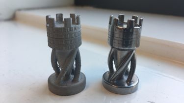 Two rook chess pieces, one 3D printed and sintered, one also polished to make it shiny