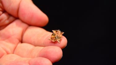 Origami robot being held in the palm of a hand