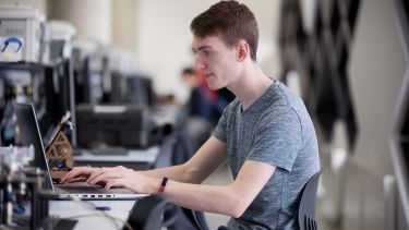 Student uses a laptop to make changes to their project
