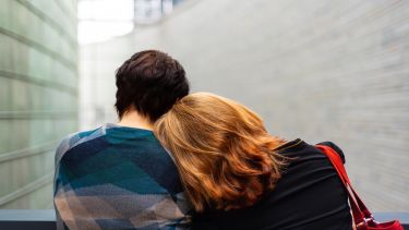 Photograph of someone resting head on anothers shoulders