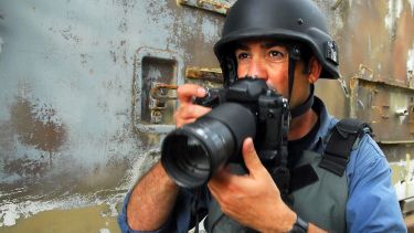 A war journalist prepares to take a photo