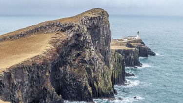 A lighthouse by the sea on a remote Scottish island.