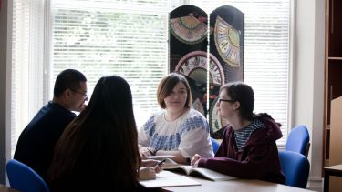 Founr students sat around a table talking