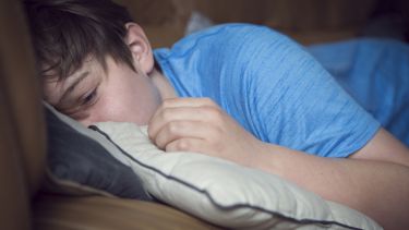 A child consoling themselves into a pillow