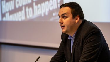 A profile photograph of Journalism Studies graduate Daniel Sheridan giving a talk. 