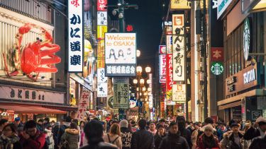 People walking down a busy street in Osaka, Japan.