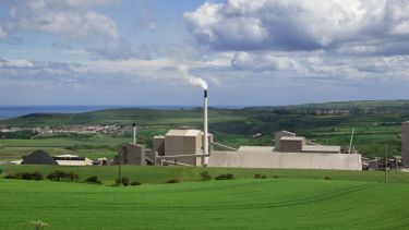 A view of the former mine that's now Boulby Underground Laboratory from the outside. Rolling hills and the sea are visible in the background.