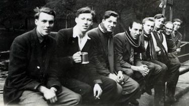 Black and white photo of Edward Ward and friends sat on a wall at the Forge Dam