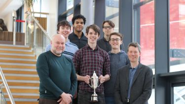 Members of the iMechE Design Challenge team holding a trophy and certificate