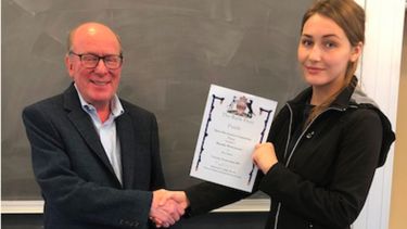 Klaudia shaking hands with Professor Maurice Skolnick as she is awarded her certificate