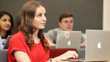 Undergraduate with laptop in classroom 