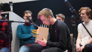 Student playing a self-designed instrument