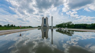 Large tower building located at the end of a body of water