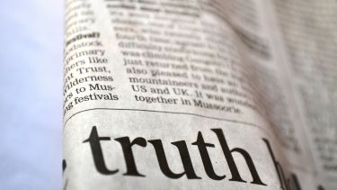 Section of newsprint with the word 'truth' in a headline