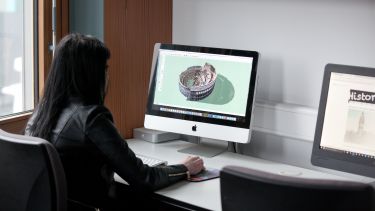 A postgraduate history student viewing a rendering of a castle on a Mac computer.