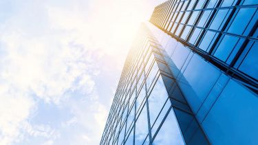 A skyline building and sun shining down