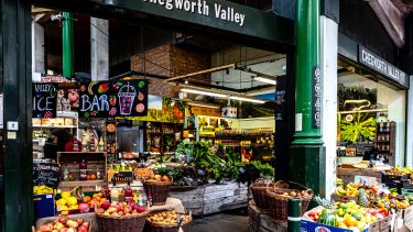 Chegworth Valley sign above indoor food market with fruit and veg