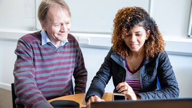 Tutor and student using computer