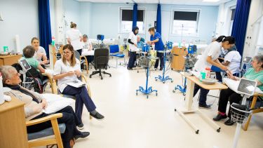Nursing students with patients in clinical setting