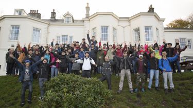 Large group of students pose outside hotel in the Lake District