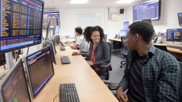 Students sitting at desks, using financial software in the Management School Trading Room