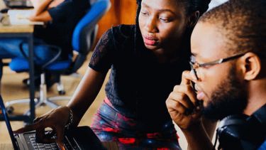 Two people using a laptop