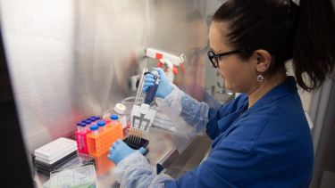 Woman in lab using pipette equipment