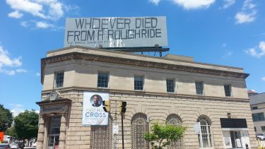 Sign in Baltimore saying 'Whoever died from a rough ride'