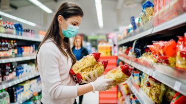Shopper buying pasta with mask and gloves