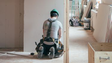 A builder at work on a newly constructed house