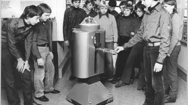Group of students around an old robot