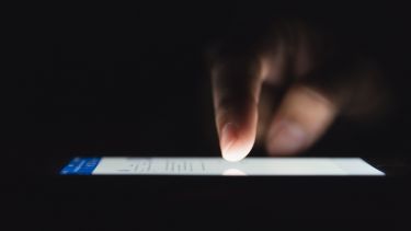 A woman's finger scrolling through social media on a phone