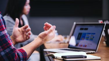 A man and a women sitting at a meeting table