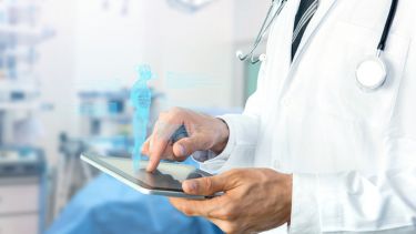A medical professional holding an iPad