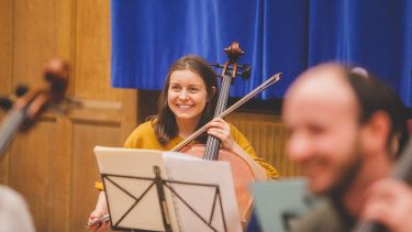 cello player smiling in rehearsal
