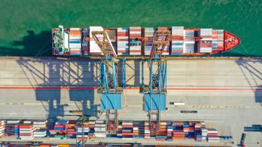 An overhead view of cargo containers being loaded onto a cargo ship