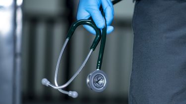 A close up of a hand holding a stethescope