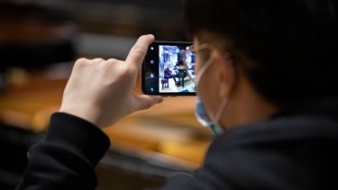 Student taking footage of pianist