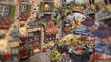 Pam's intricate cross-stitch of a European style piazza and cafe scene
