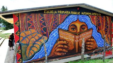Escuela Primaria Rebelde Autonoma Zapatista mural with woman reading a book