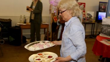 A woman holding plates of food at the Imagine north east exhibition launch