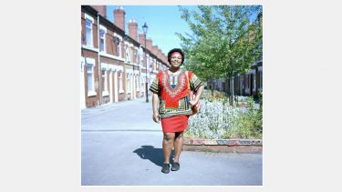 A young woman wearing traditional African dress on the street in Hillfields