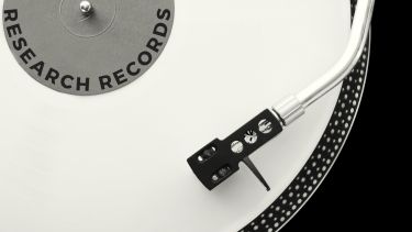 A black and white zoomed image of a record and record player