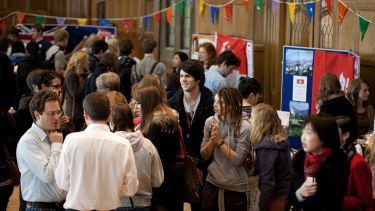 Students attend a faculty induction event in a large hall