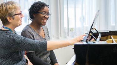 Tutor teaching piano 