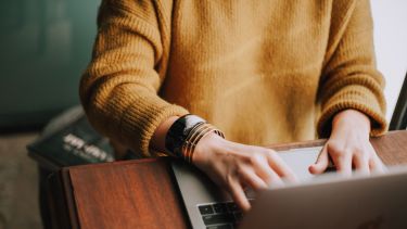 Close up of person's hands using a laptop