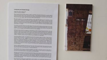 Wall of text and image of building at art exhibition